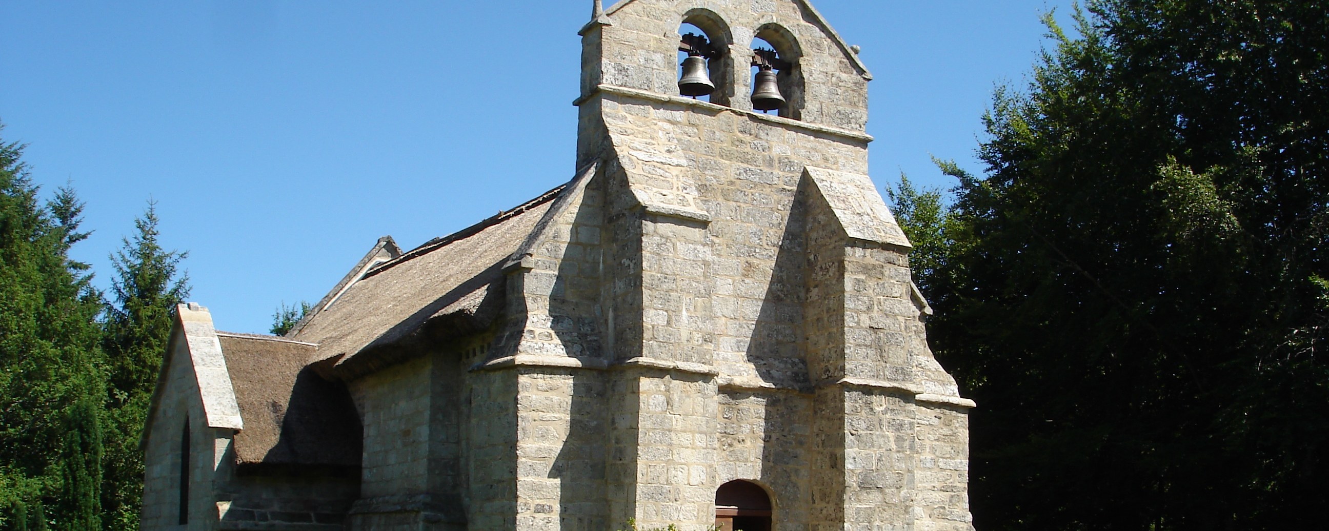 Église Saint-Martial de Lestards from the south-west, the granite wall-belfry and the rye-straw thatched nave roof